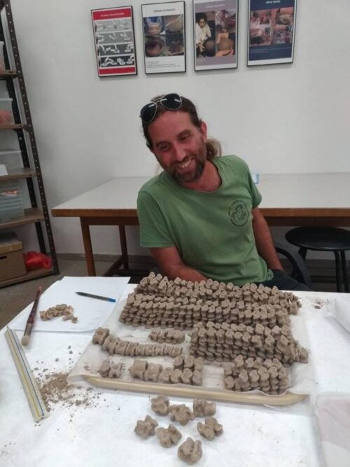 Area B supervisor and faunal analyst, Ariel Shatil, admires the 425 astragali sheep, goat, gazelle, and deer. Photography by Nava Panitz-Cohen.