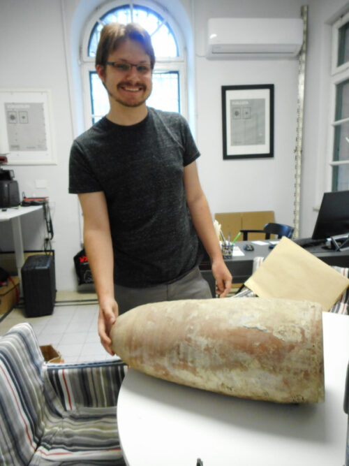 Conor McCracken-Flesher holds the vessel steady. Note the white deposits on this side of the jar. Image courtesy of Joan Taylor.