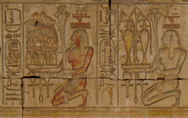 Nome deities presenting goods, temple of Ramesses II at Abydos. The hetep hieroglyph appears in the center of the goods. Photo by Olaf Tausch, CC by-SA 3.0.