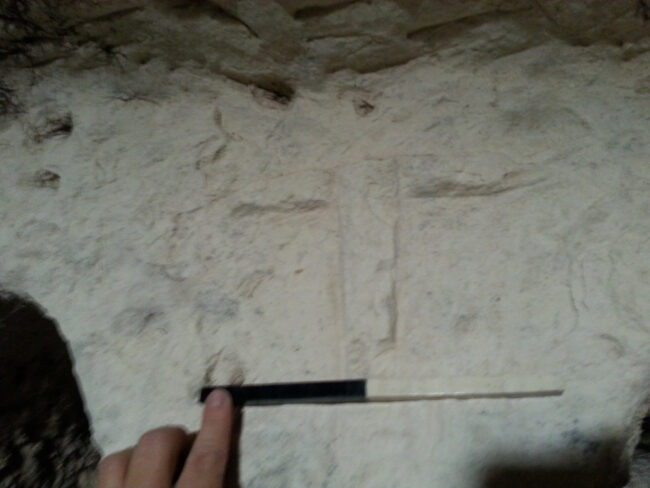 Tau cross in engraved in relief on the limestone wall of the tomb at Ḥorvat Sa‘adon (estimated size: 18 x 18 cm). Courtesy of the Israel Antiquities Authority.