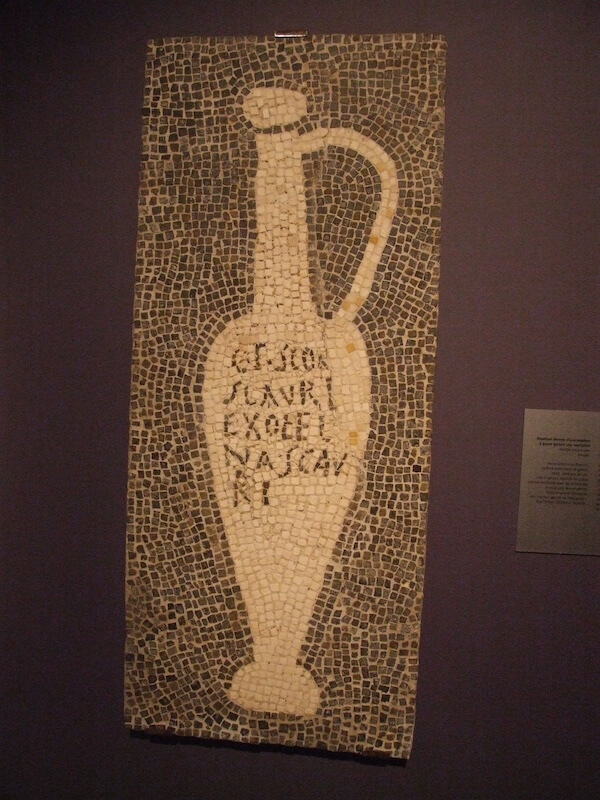 Mosaic depicting a "Flower of Garum" jug with a titulus reading "from the workshop of [the garum importer Aulus Umbricius] Scaurus". Photo by Claus Ableiter. CC-By-SA