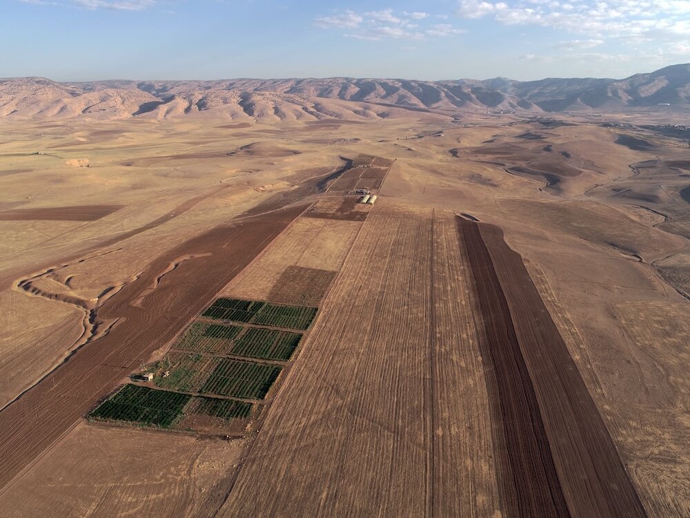 The countryside of Assyria, fertile plains against the majestic backdrop of the Zagros mountains. Photo courtesy of the authors.