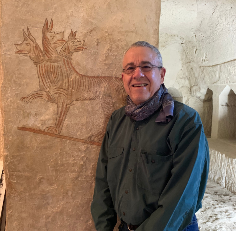 David Hendin with an ancient depiction of Cereberus at the Sidonian Cave in Marisha, Israel. Credit: R. Hendin.