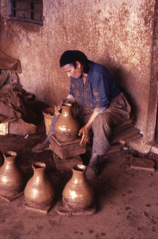 On a series of jugs, Paraskavi at the Kornos Pottery Cooperative decorated a jug using a spliced bamboo stalk prior to attaching a handle. Bases later were scraped into a rounded form. June 1986. Photo by the Author.