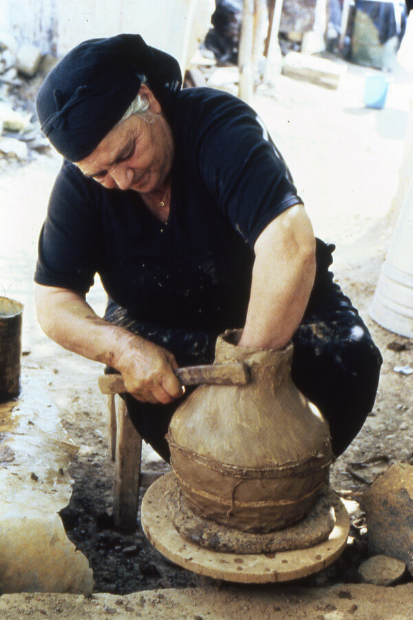 With a split bamboo tool, Christinou pulled up the clay to form the neck on a coil-built jug at Agios Demetrios. July 1986. Photo by the Author.