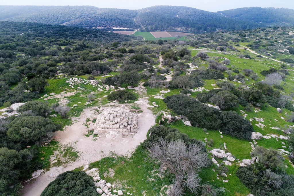 Figure 5: An aerial view of the pyramidal funerary monument and the opening of the collapsed burial cave to its north, looking west (Photo: T. Rogovski)