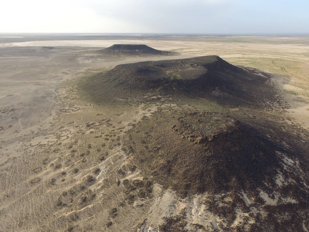 Figure 2: Collapsed prehistoric structures along the shoulders of Mesa 7 on Wadi al-Qattafi. Photo by A. C. Hill.