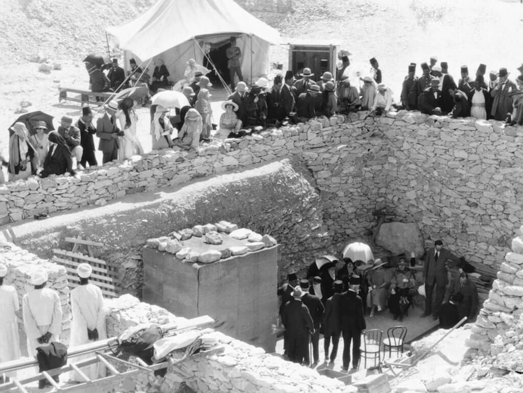 Tourists crowd around the retaining wall surrounding the pit containing the entrance to Tutankhamun's tomb (KV62) in the Valley of the Kings, during the period in late February 1923 when the tomb was first opened for public viewing. From the magazine article "At the Tomb of Tutankhamen" by Maynard Owen Williams in the May 1923 issue of National Geographic. Public Domain.