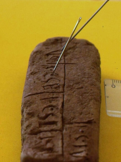 By putting needles into the punctured holes left by the stylus, Gerrit van der Kooij carefully analyzed the angle of the tool used and the writing direction of the tablets. (Photo courtesy of Gerrit van der Kooij.)