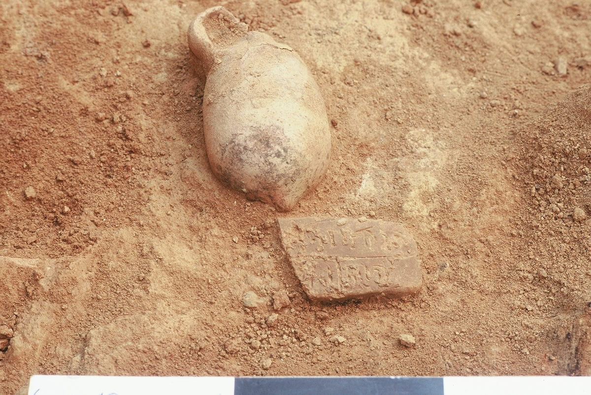 A fragment of tablet 3524 found in situ next to a Late Bronze Age juglet on the floor of a large hall. (Photo courtesy of Gerrit van der Kooij.)