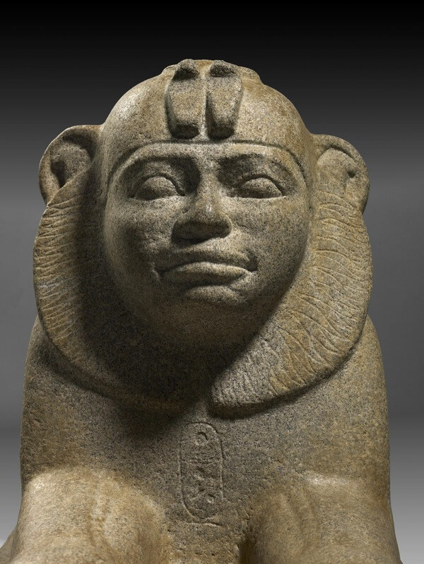 Granite (probably granite gneiss) sphinx of Taharqo wearing skull-cap and double-uraeus; cartouche on breast. © The Trustees of the British Museum