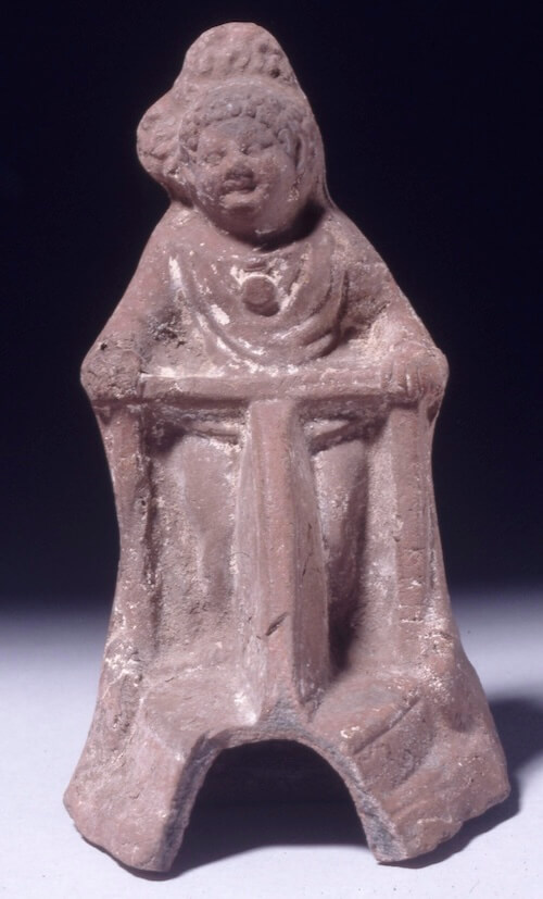 Terracotta figure of a child walking with the aid of a wheeled frame. The child has one leg which appears to be less muscular than the other and walks with a crouch gait: both commonly associated with cerebral palsy.