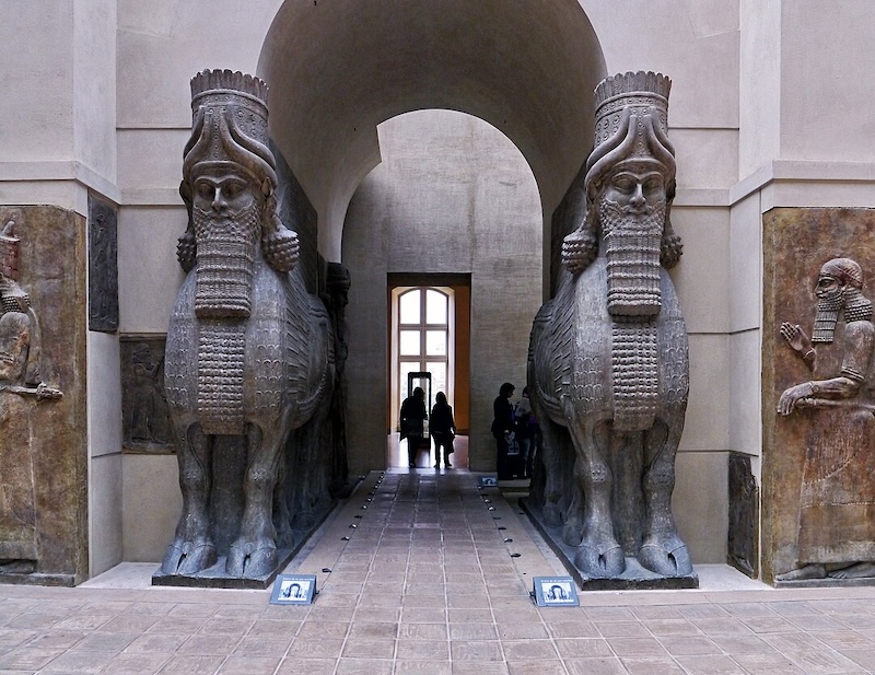 Lamassu (hybrid Assyrian guardian deities with the head of a human, body of a bull, and wings of an eagle) from the palace of Sargon II at Dur-Sharrukin (ca. 722-705 BCE), now at the Louvre, Paris. Photo by Poulpy, CC By-SA 3.0.