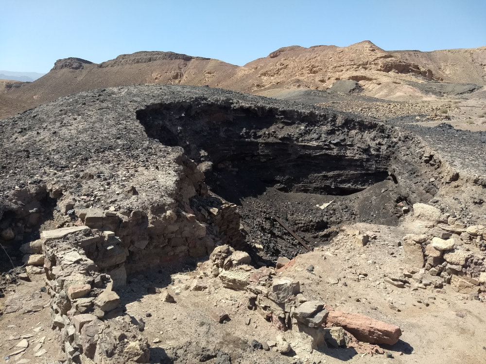 Deep slag mound at Khirbet en-Nahas, with adjoining buildings. © J.M. Tebes