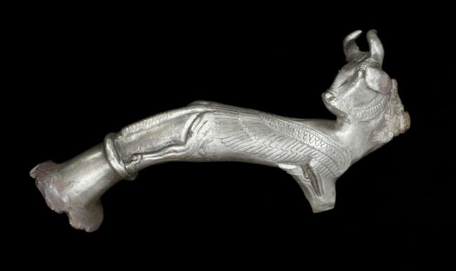 Fig. 4: Handle in the form of a winged bull creature, excavated at Babylon, early 4th cen. BCE. Silver; 13.1 × 3.6 cm. British Museum 1882,1220.24. Image reproduced courtesy of the Trustees of the British Museum under a Creative Commons license (CC BY-NC-SA 4.0).