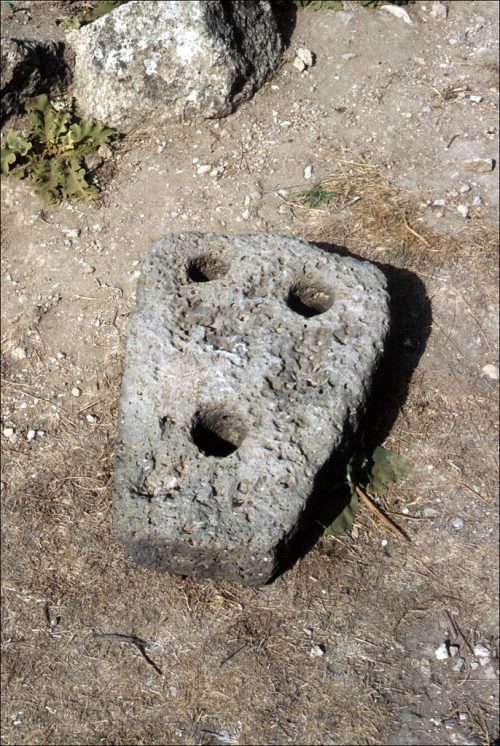 Stone anchor from the Temple of Baʿal at Ugarit, likely serving as an offering by those who spent their life at sea and related to a maritime cult. Photo by Mike Bishop, CC BY-NC-SA 2.0.